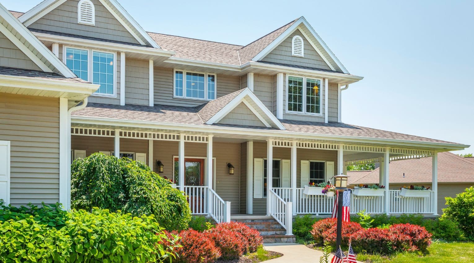 Tan house with wraparound front porch